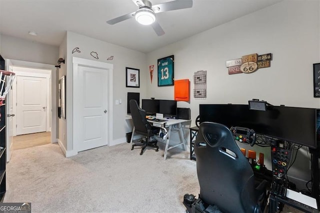 carpeted home office featuring baseboards and a ceiling fan