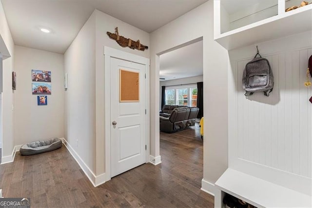 interior space featuring baseboards and dark wood-style flooring