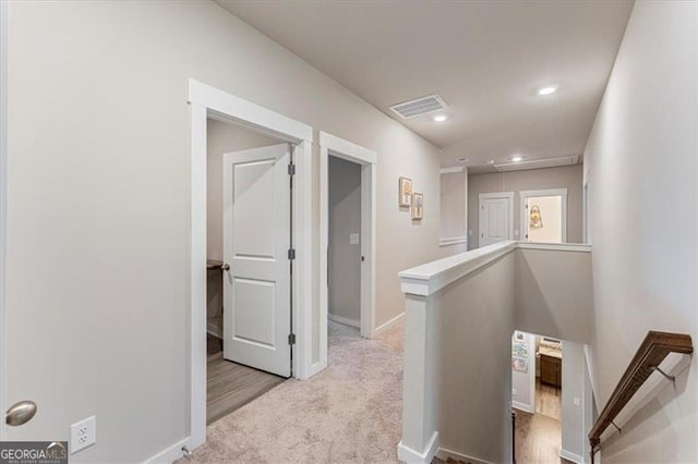 corridor with recessed lighting, carpet floors, visible vents, an upstairs landing, and baseboards