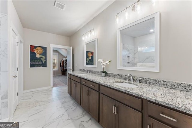 bathroom with marble finish floor, double vanity, a sink, and visible vents