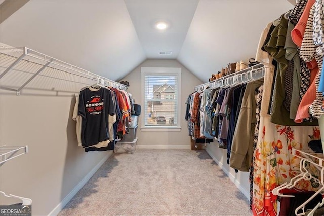 spacious closet featuring carpet, visible vents, and vaulted ceiling