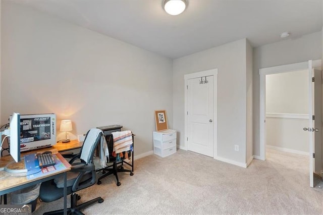 home office with baseboards and light colored carpet