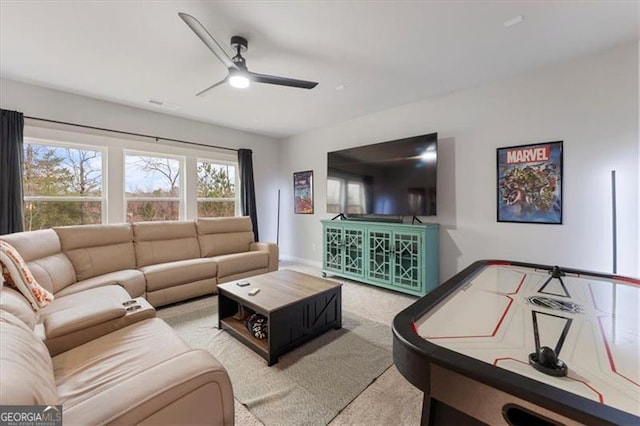 living area with ceiling fan, carpet flooring, and baseboards