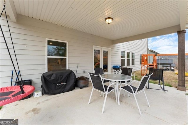 view of patio / terrace featuring a playground, outdoor dining area, and grilling area