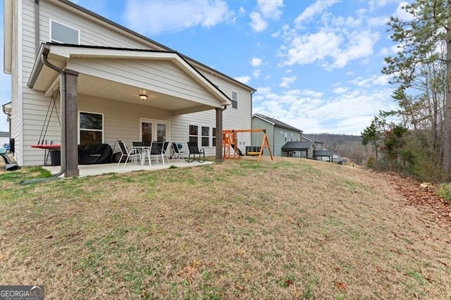 rear view of house featuring a patio area and a yard