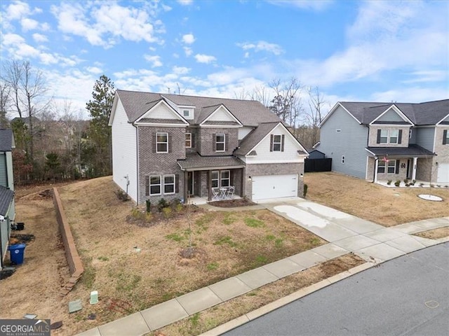 traditional-style house featuring driveway, a garage, a porch, a front lawn, and brick siding