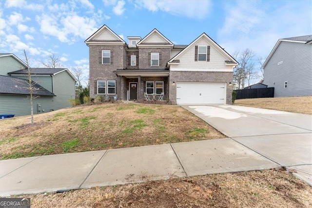 view of front of property with brick siding, a front yard, fence, a garage, and driveway