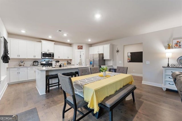 dining space with light wood-style floors, baseboards, and recessed lighting