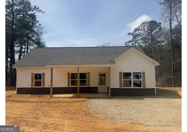 view of front of house with stone siding and a shingled roof