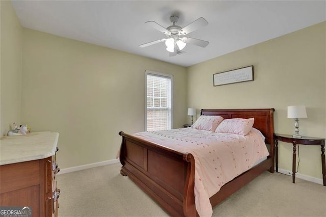 bedroom with light colored carpet, ceiling fan, and baseboards