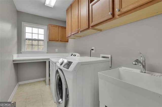 laundry room featuring light tile patterned floors, cabinet space, a sink, washer and dryer, and baseboards