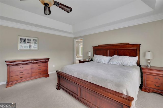 bedroom featuring baseboards, a tray ceiling, ornamental molding, and light colored carpet