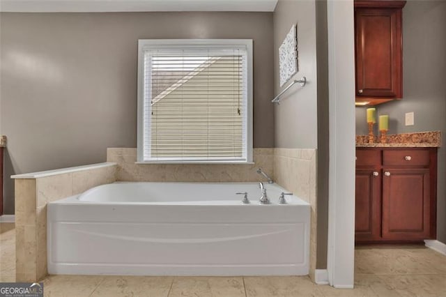 bathroom with tile patterned floors, a bath, and vanity