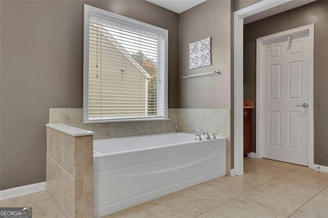 full bath featuring a garden tub and baseboards