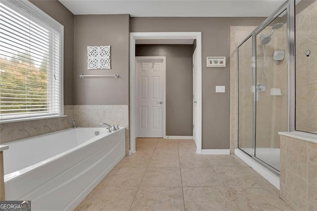 full bathroom with a stall shower, tile patterned flooring, baseboards, and a garden tub