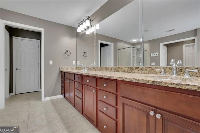 full bath with double vanity, visible vents, a sink, a shower stall, and baseboards