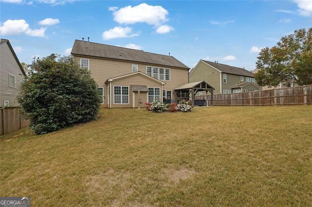 back of property featuring a gazebo, a lawn, and fence private yard