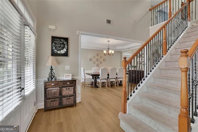 foyer entrance featuring light wood-type flooring, a high ceiling, and a wealth of natural light