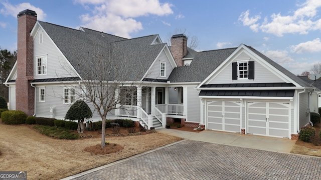 view of front of property with a standing seam roof, a chimney, and concrete driveway