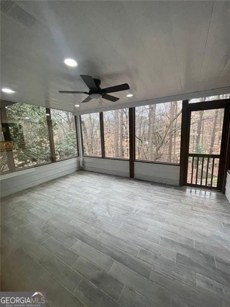 unfurnished sunroom featuring ceiling fan