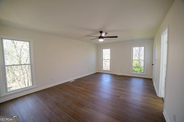 unfurnished room with ceiling fan, baseboards, and dark wood-style floors