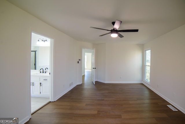 spare room featuring visible vents, a sink, wood finished floors, baseboards, and ceiling fan