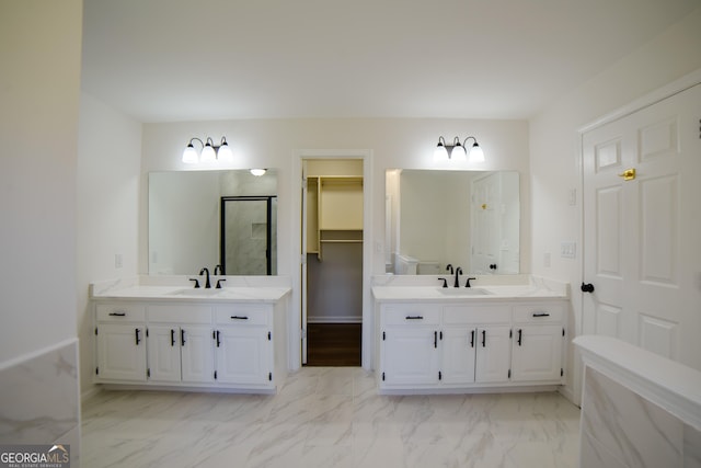 bathroom featuring marble finish floor, two vanities, and a sink