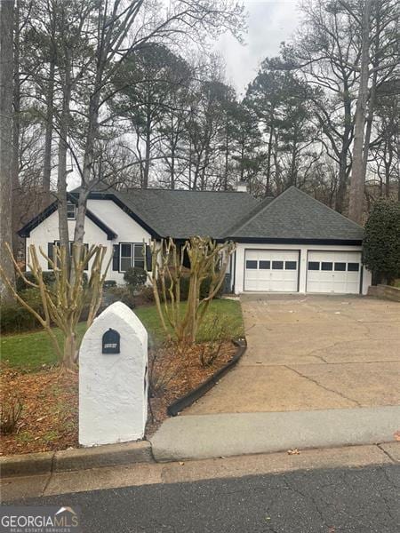 ranch-style home featuring a garage and driveway