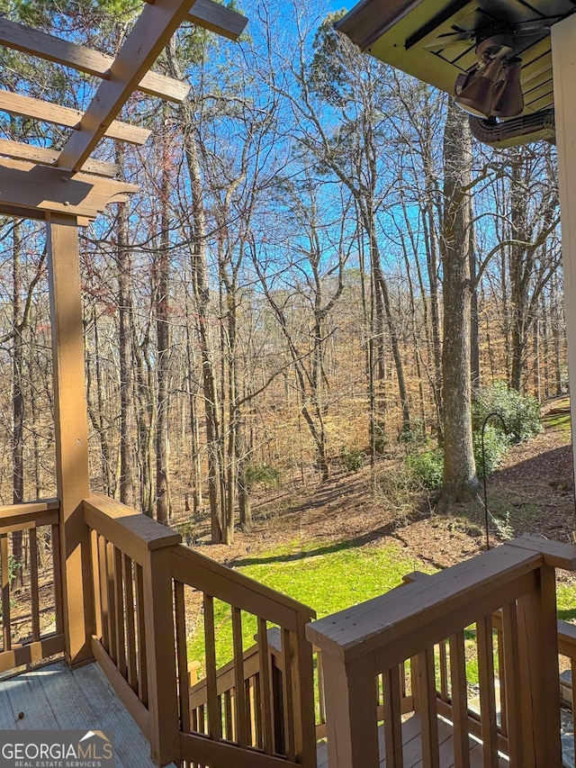 wooden deck with a pergola and a forest view