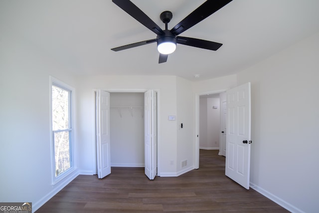 unfurnished bedroom featuring a closet, a ceiling fan, baseboards, and dark wood-style flooring