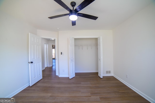 unfurnished bedroom with visible vents, dark wood-type flooring, baseboards, a closet, and a ceiling fan