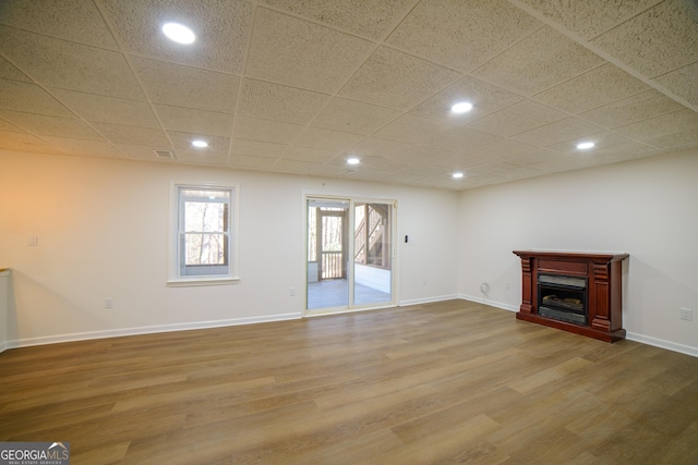 below grade area with recessed lighting, baseboards, wood finished floors, and a fireplace