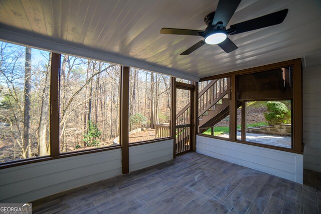 unfurnished sunroom featuring wooden ceiling and a ceiling fan