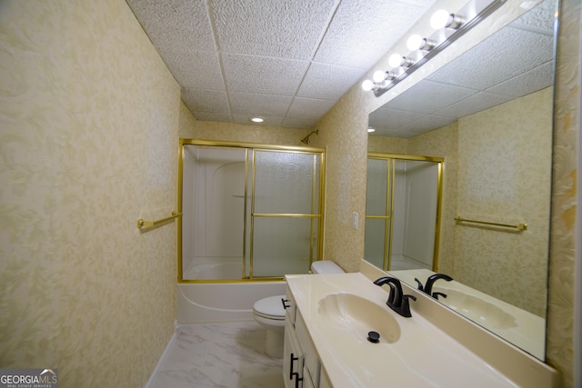 full bathroom with a drop ceiling, toilet, marble finish floor, and vanity
