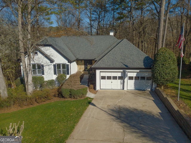 view of front of home with stucco siding, a chimney, a front yard, and a shingled roof