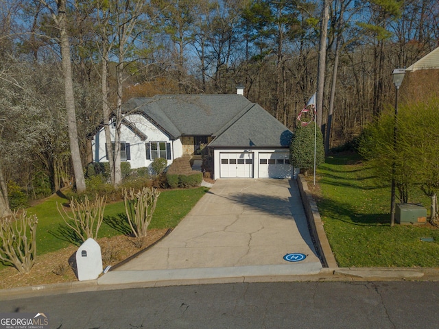 view of front of house with a front lawn, an attached garage, concrete driveway, and roof with shingles