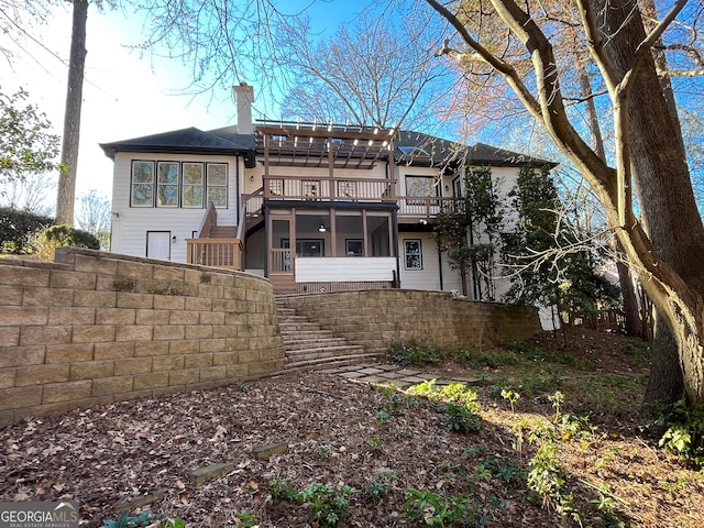 back of house with stairway, fence, a sunroom, and a chimney