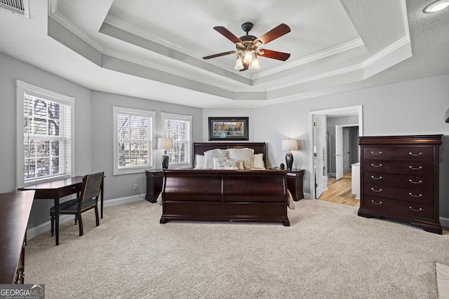 bedroom with visible vents, a tray ceiling, light colored carpet, and ornamental molding