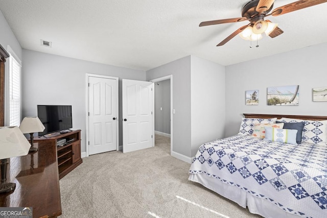 bedroom with a ceiling fan, baseboards, visible vents, and carpet flooring