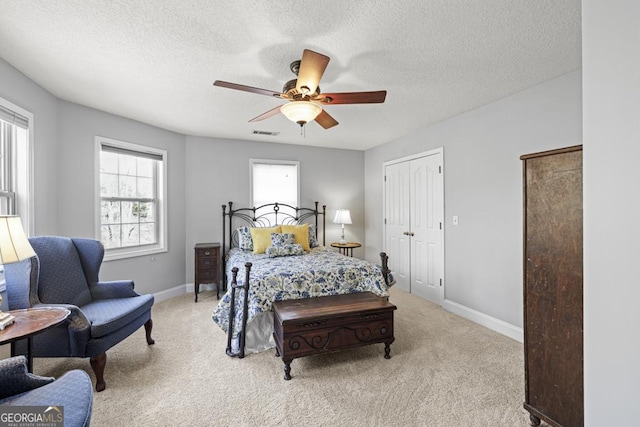 bedroom with light colored carpet, visible vents, ceiling fan, a textured ceiling, and baseboards