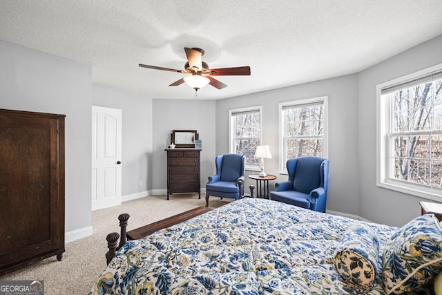 bedroom featuring a ceiling fan, carpet, a textured ceiling, and baseboards