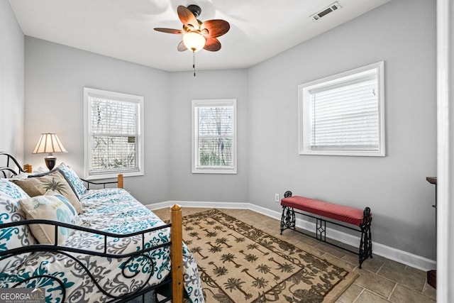 bedroom featuring a ceiling fan, visible vents, and baseboards