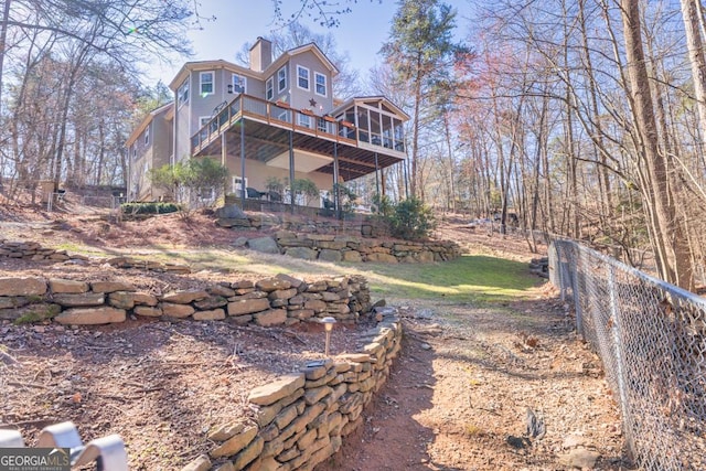 rear view of property with stairway, a chimney, a wooden deck, and fence