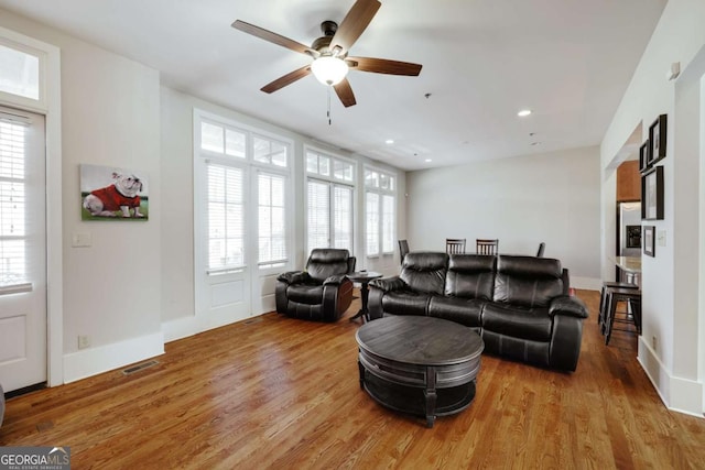 living area featuring recessed lighting, a healthy amount of sunlight, visible vents, and wood finished floors