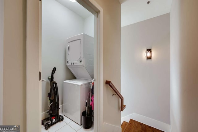 laundry area featuring laundry area, tile patterned flooring, baseboards, and stacked washer / dryer