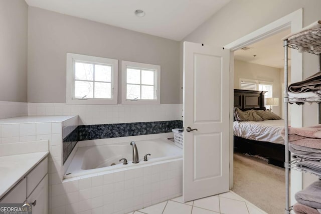 full bathroom with ensuite bathroom, vanity, a bath, and tile patterned floors