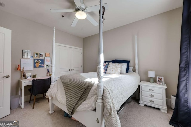 bedroom featuring light carpet, ceiling fan, visible vents, and a closet