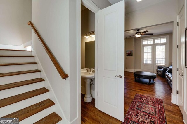 stairway featuring wood finished floors and a ceiling fan