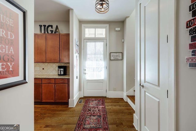 entryway featuring baseboards and dark wood-type flooring