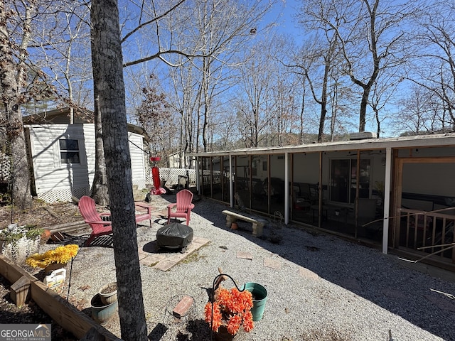 view of yard with a sunroom and an outdoor fire pit